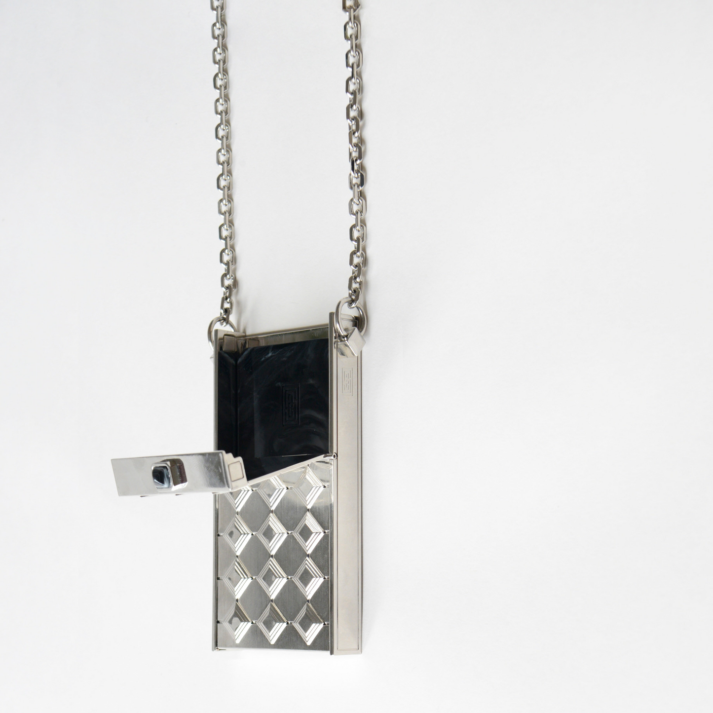 The Verneuil Case by SEDNON – silver cigarette case necklace opened to show the internal compartment, demonstrating its capacity to hold multiple types of cigarettes, a luxury handcrafted accessory combining elegance and functionality.